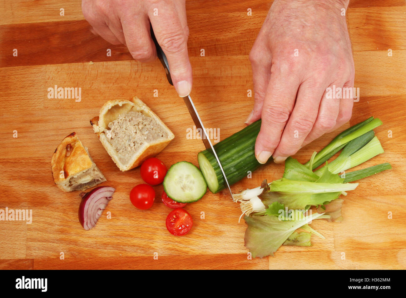 Hands preparing a salad on a wooden chopping board Stock Photo