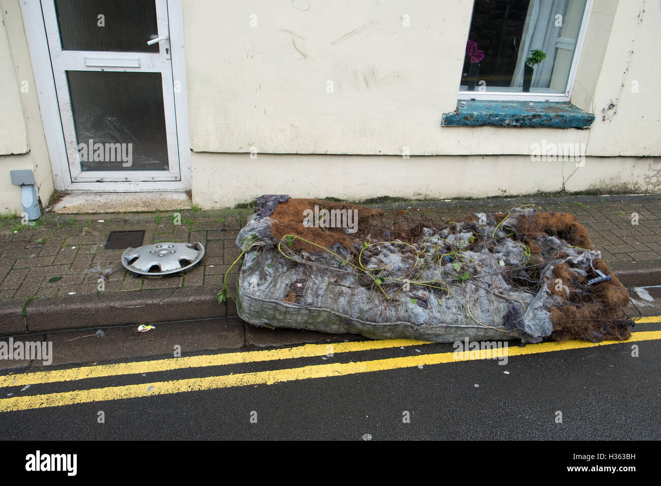 Rotten mattress dumped in the street. Stock Photo