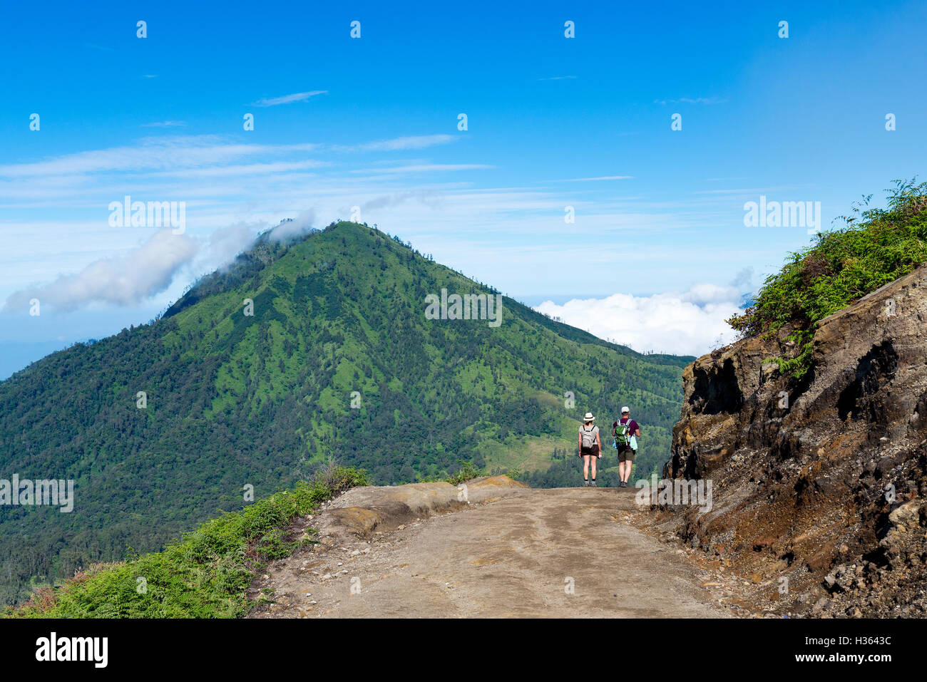 Group of hikers with backpacks walking in mountains. sky blue and ...