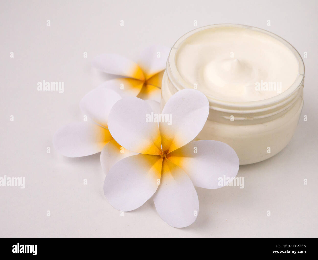 Moisturizing cream and three tiare flowers Stock Photo