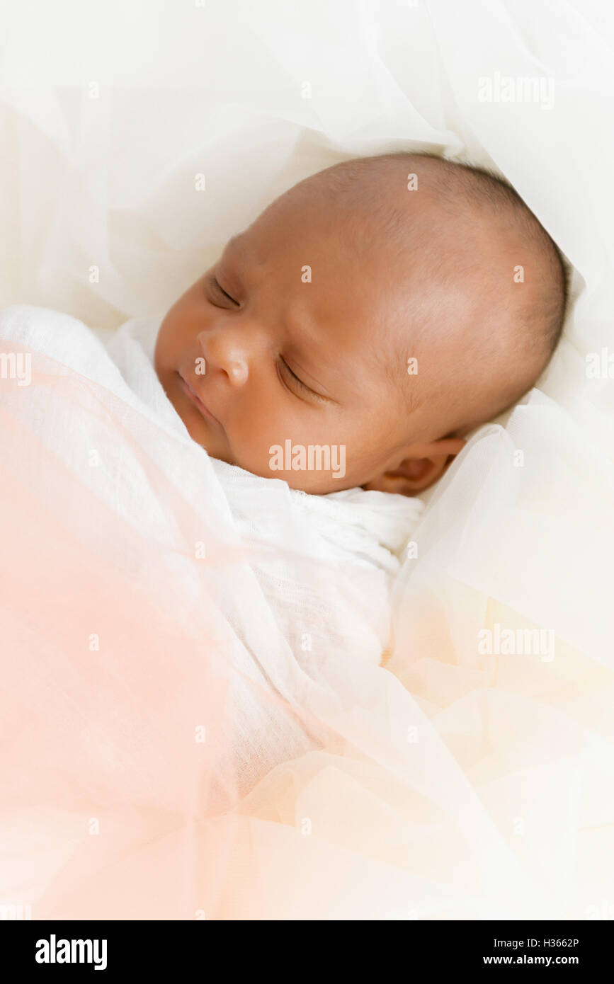 Three weeks old baby sleeping on white blanket cute infant newborn lying down close up shot eyes closed Stock Photo
