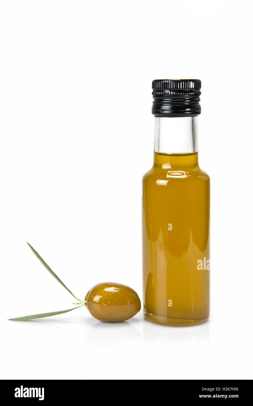 Glass bottle of premium virgin olive oil and some olives with leaves ...