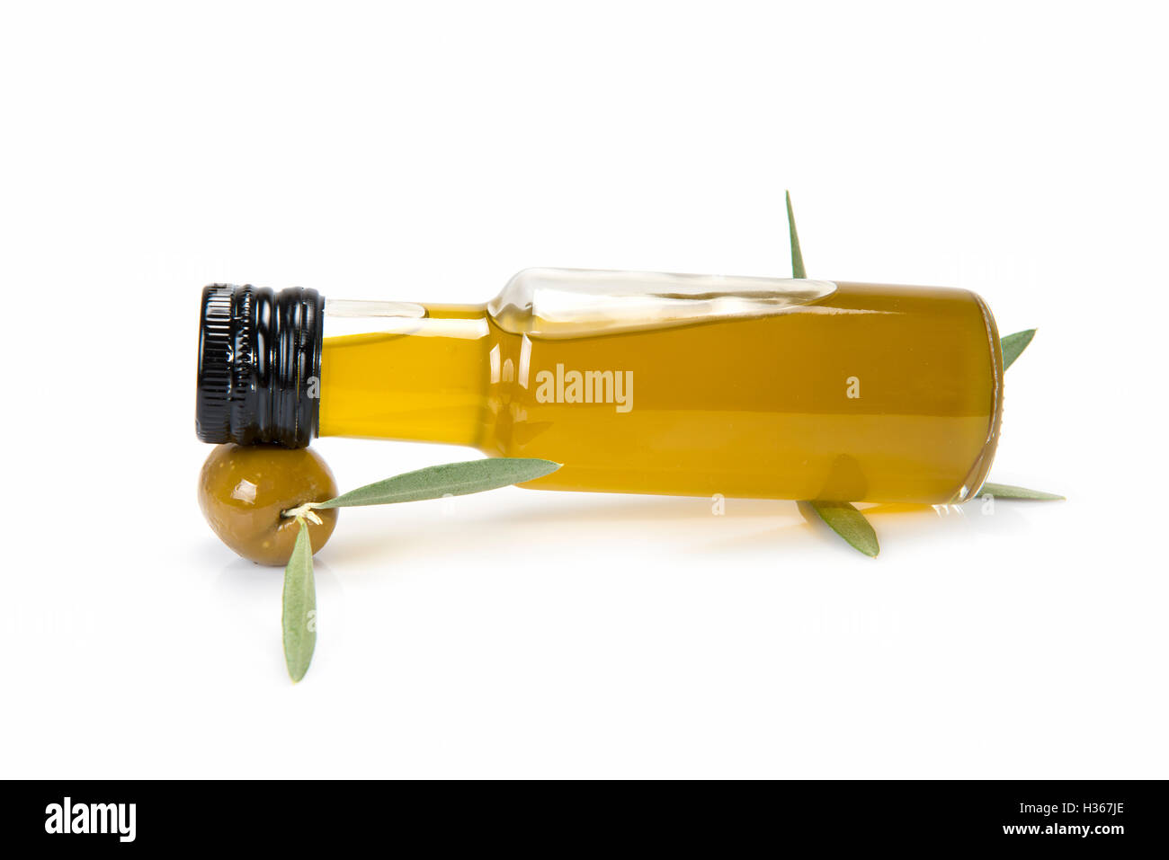 Glass bottle of premium virgin olive oil and some olives with leaves ...