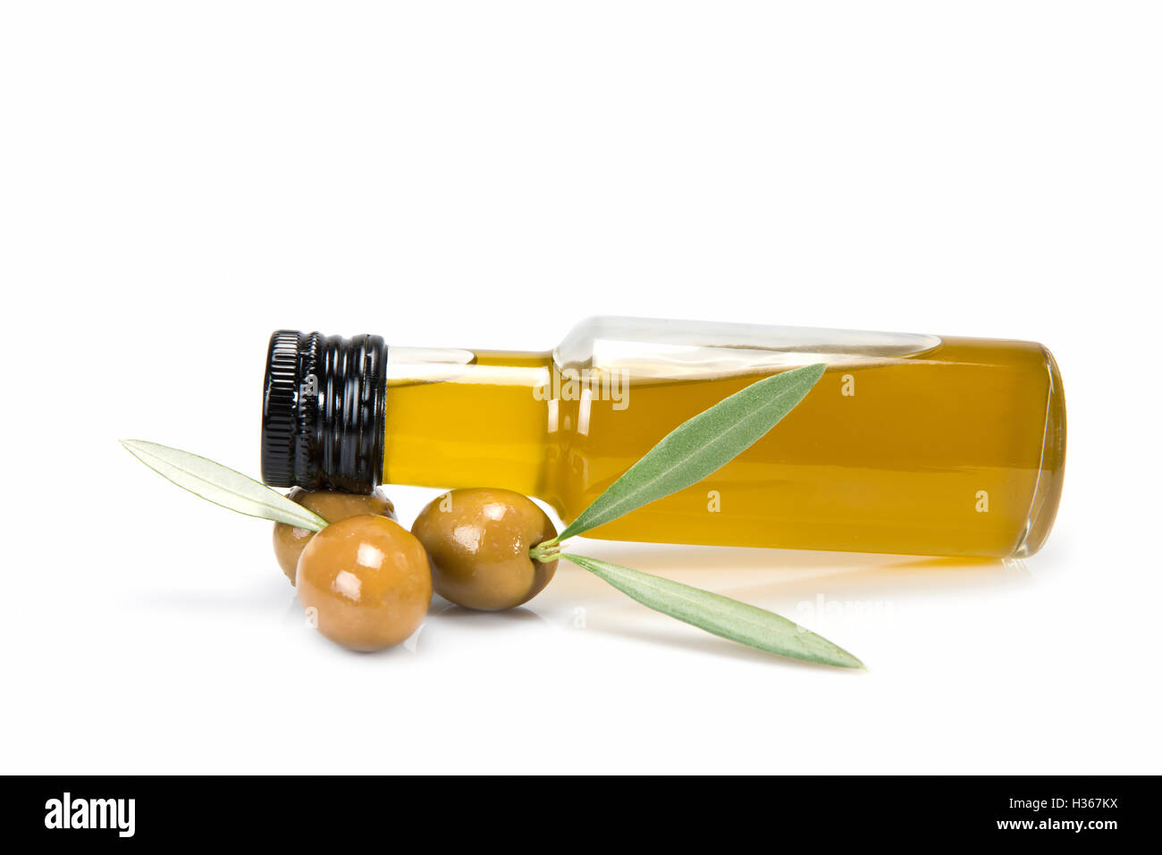 Glass bottle of premium virgin olive oil and some olives with leaves ...