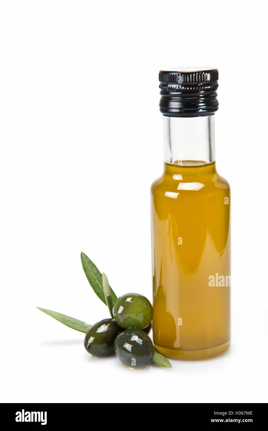 Glass bottle of premium virgin olive oil and some olives with leaves ...
