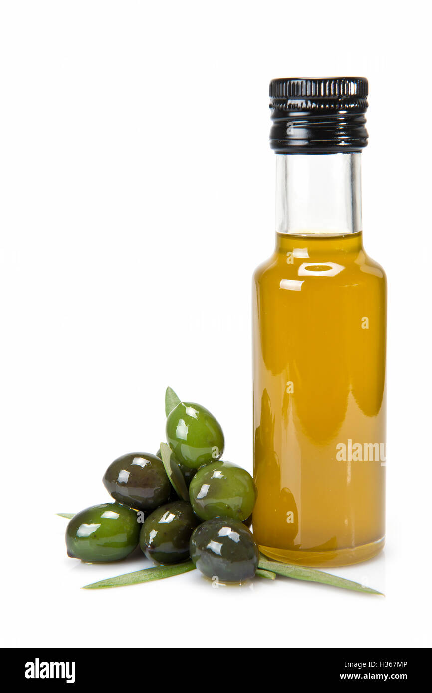 Glass bottle of premium virgin olive oil and some olives with leaves ...
