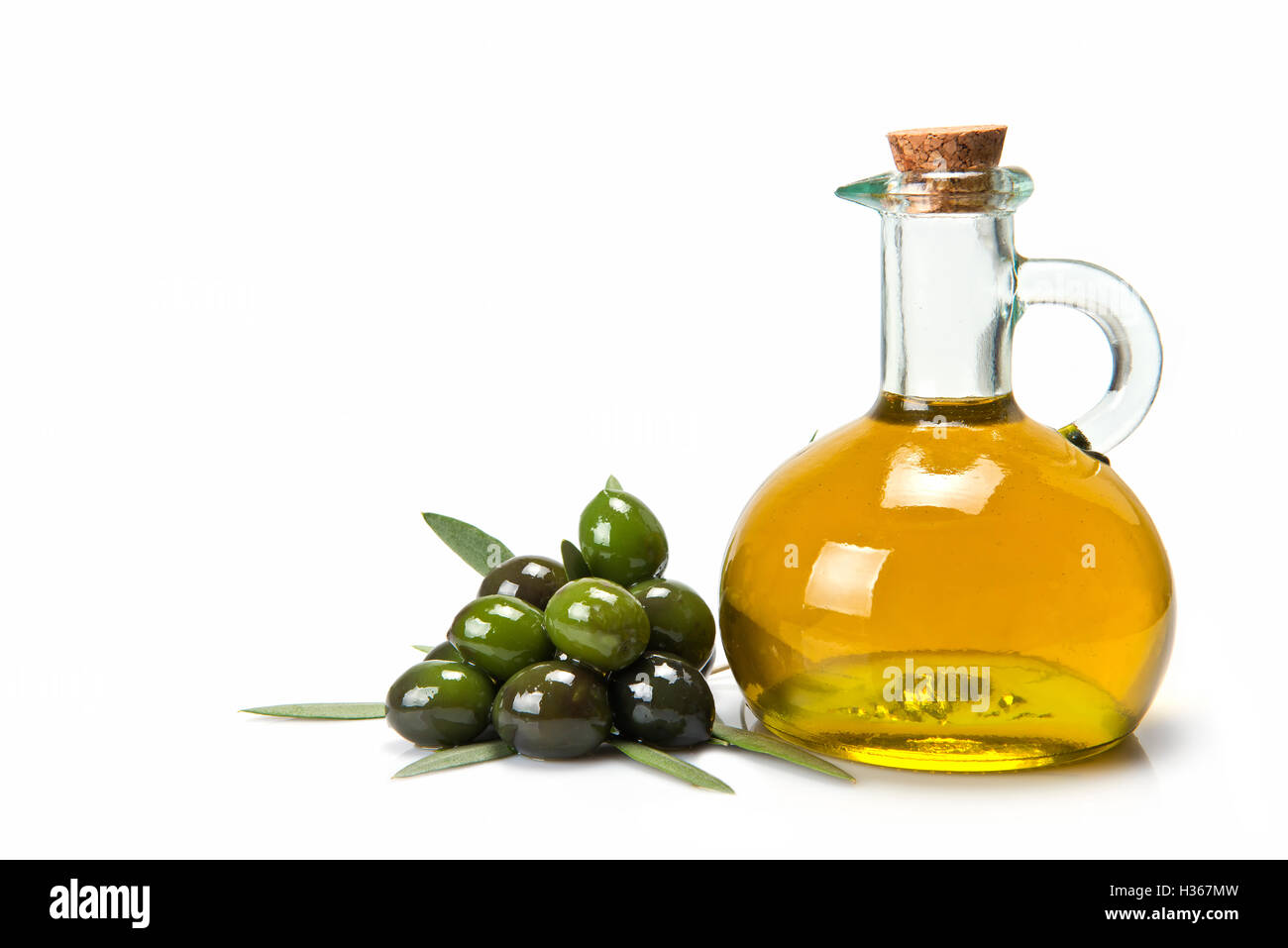 Glass bottle of premium virgin olive oil and some olives with leaves ...