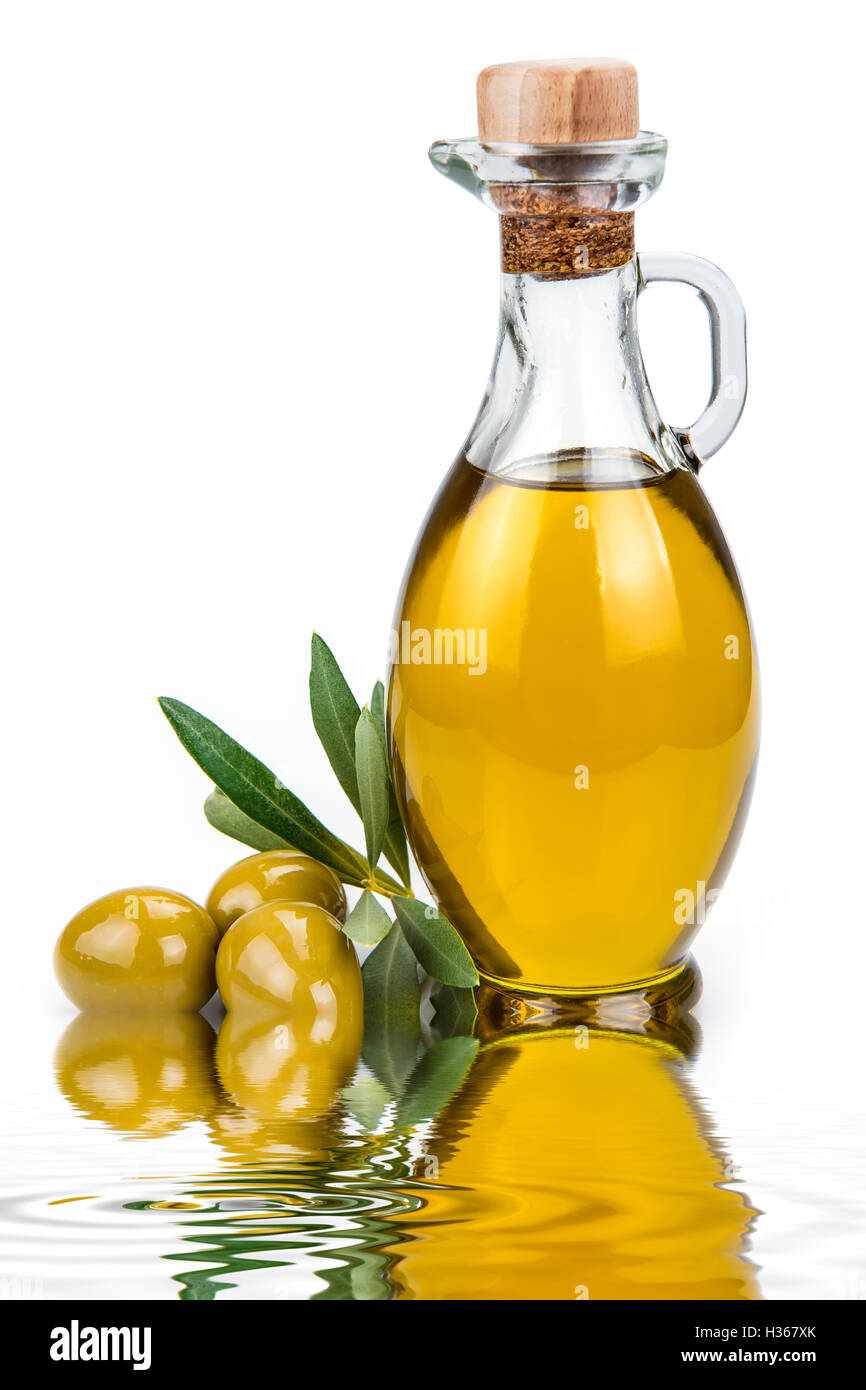Olive oil in a glass bottle and green olives isolated over a white ...