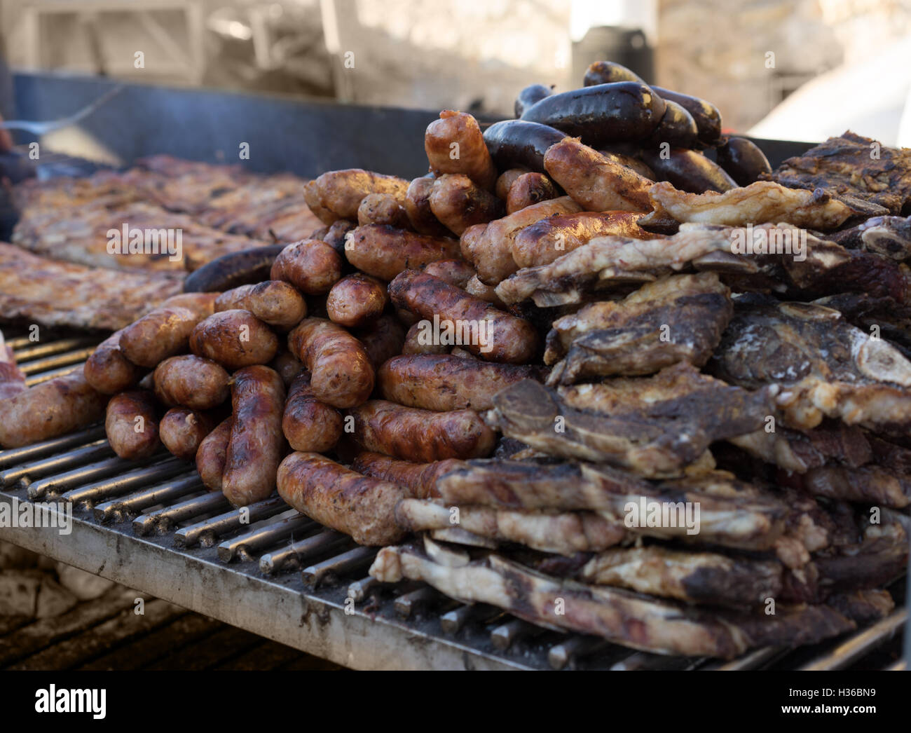 Fresh sausage and hot dogs grilling outdoors Stock Photo