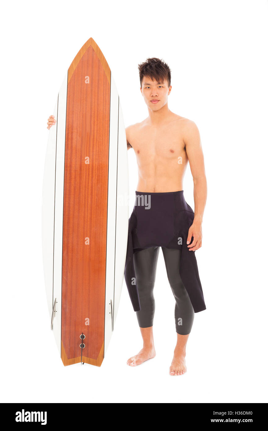 young surfer wearing diving suit and holding a surfboard Stock Photo