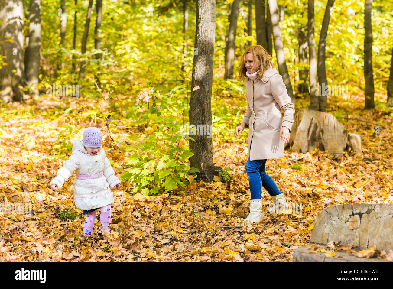 Little girl and her mother playing in the autumn park Stock Photo - Alamy