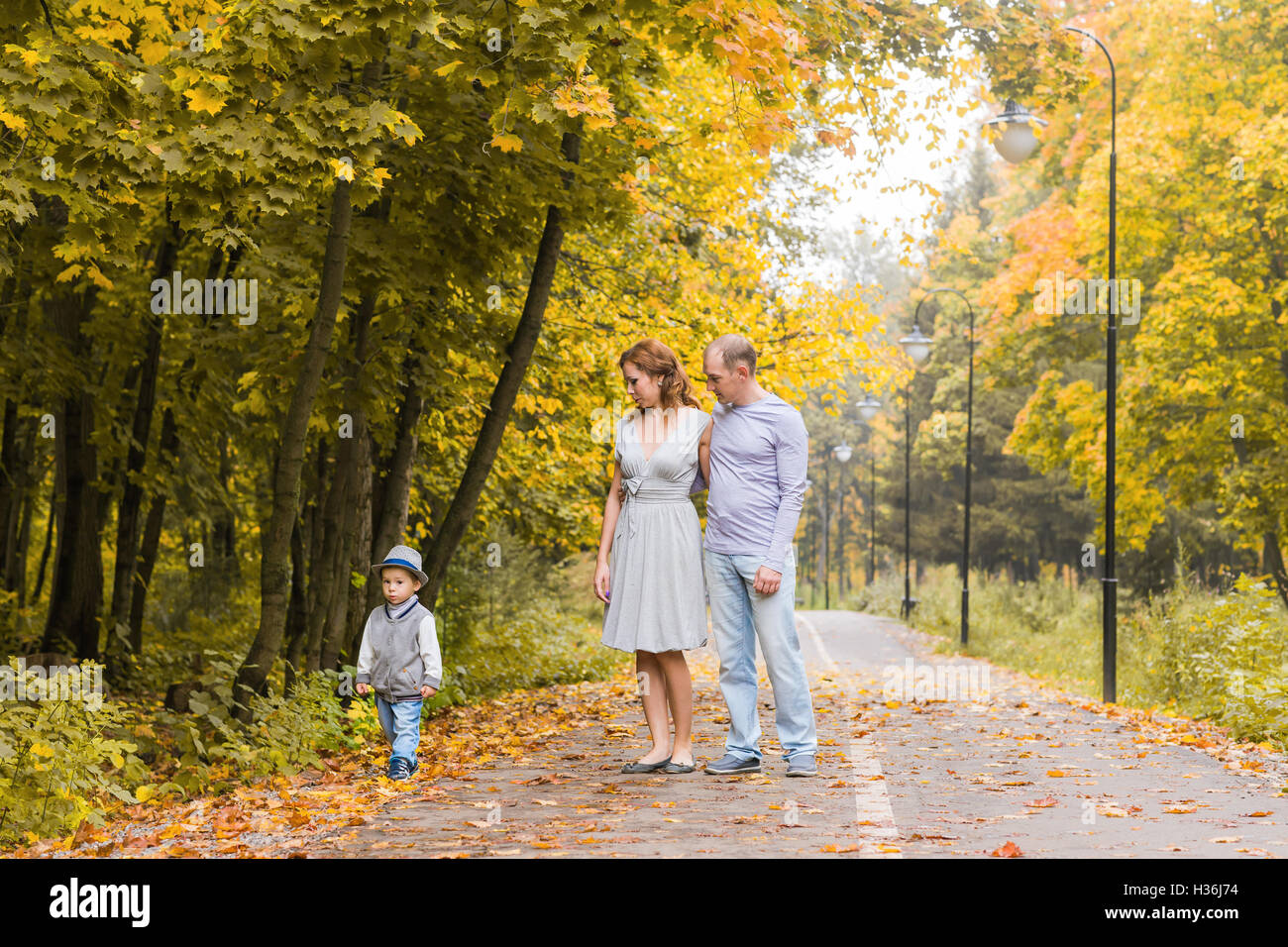 Happy family walking in autumn park Stock Photo - Alamy