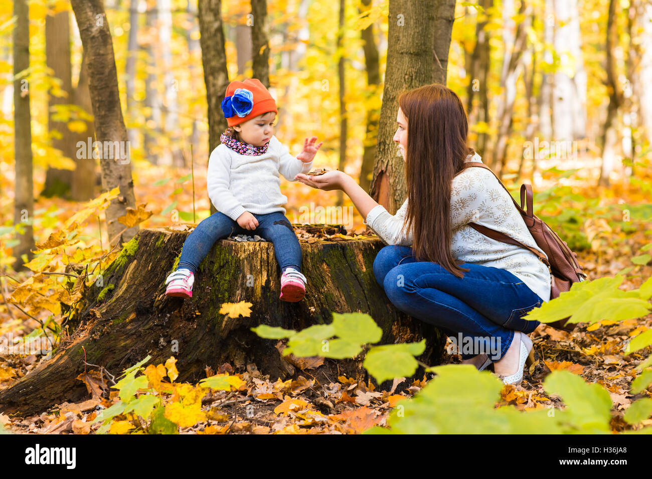 Little girl and her mother playing in the autumn park Stock Photo - Alamy