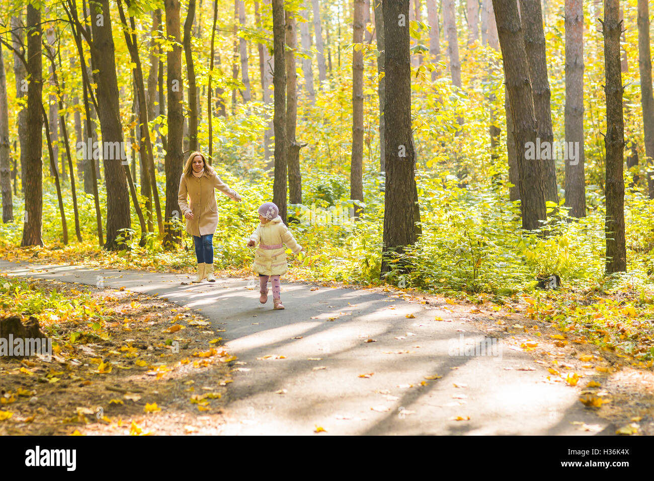 Little girl and her mother playing in the autumn park Stock Photo - Alamy