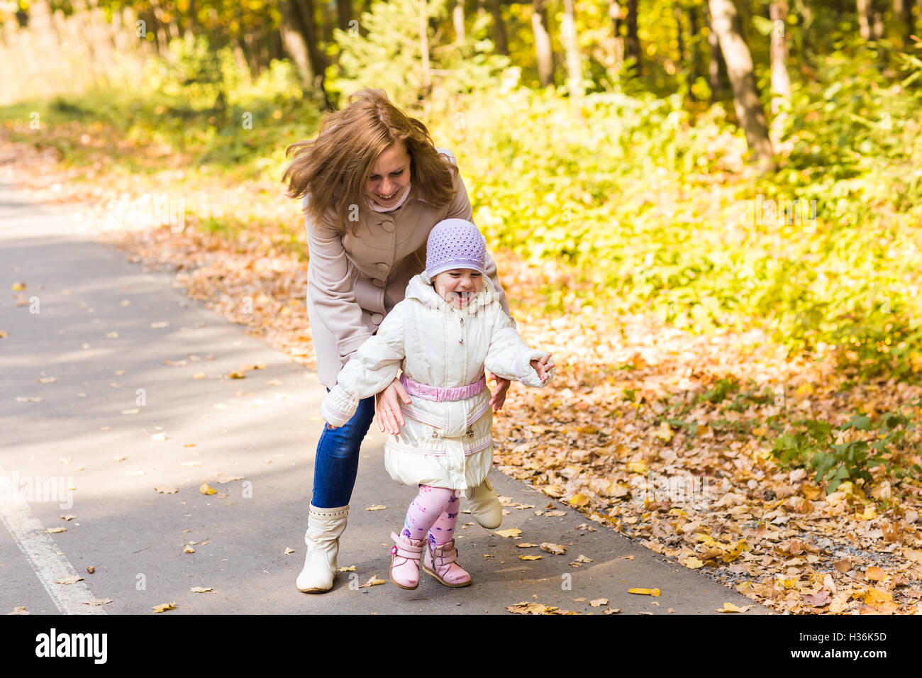 Little girl and her mother playing in the autumn park Stock Photo - Alamy