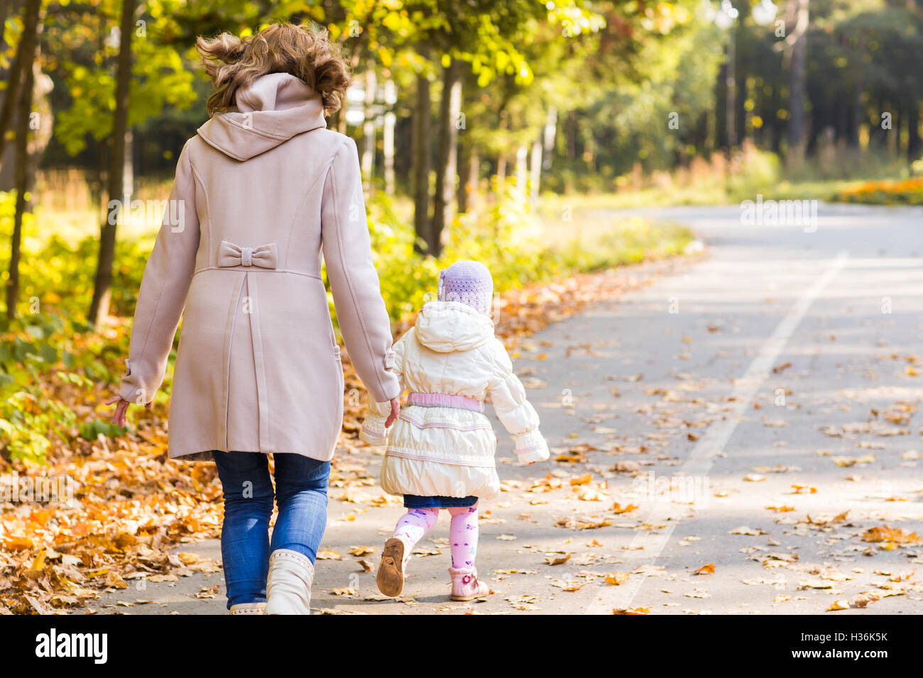Little girl and her mother playing in the autumn park Stock Photo - Alamy