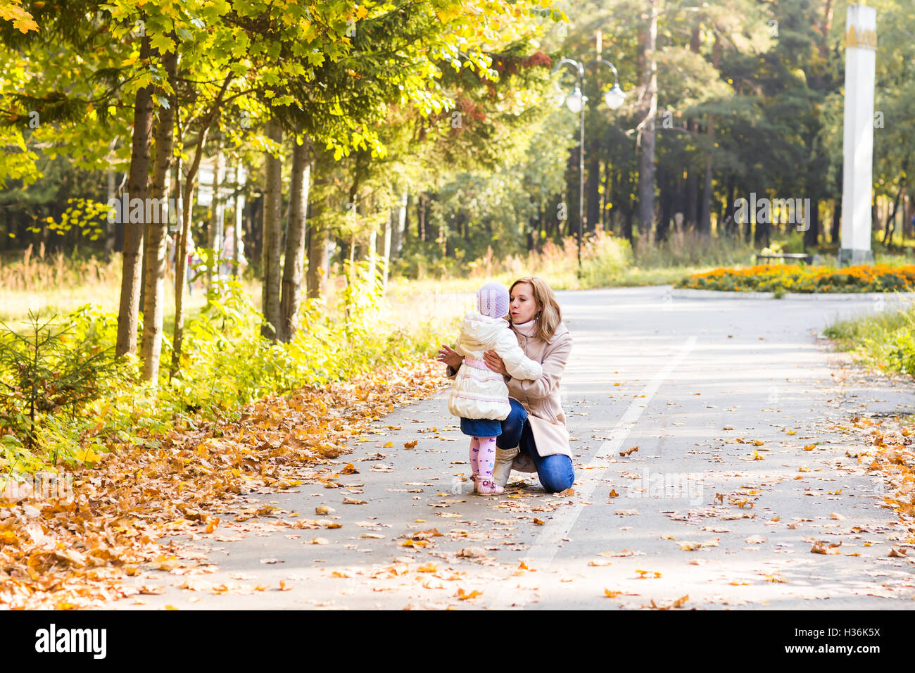 Little girl and her mother playing in the autumn park Stock Photo - Alamy