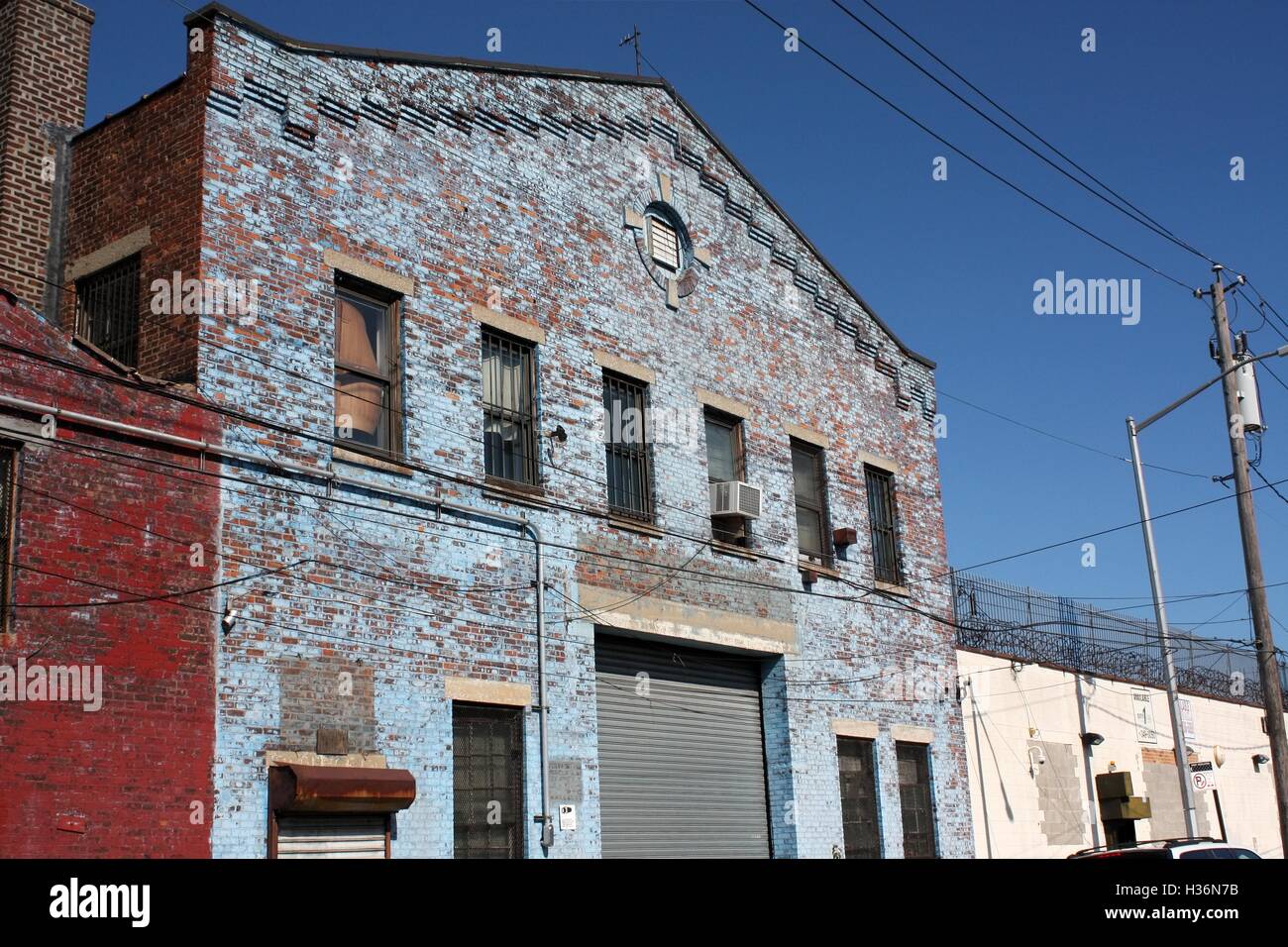 Weathered blue exposed brick facade of a warehouse in Red Hook, New York. Stock Photo
