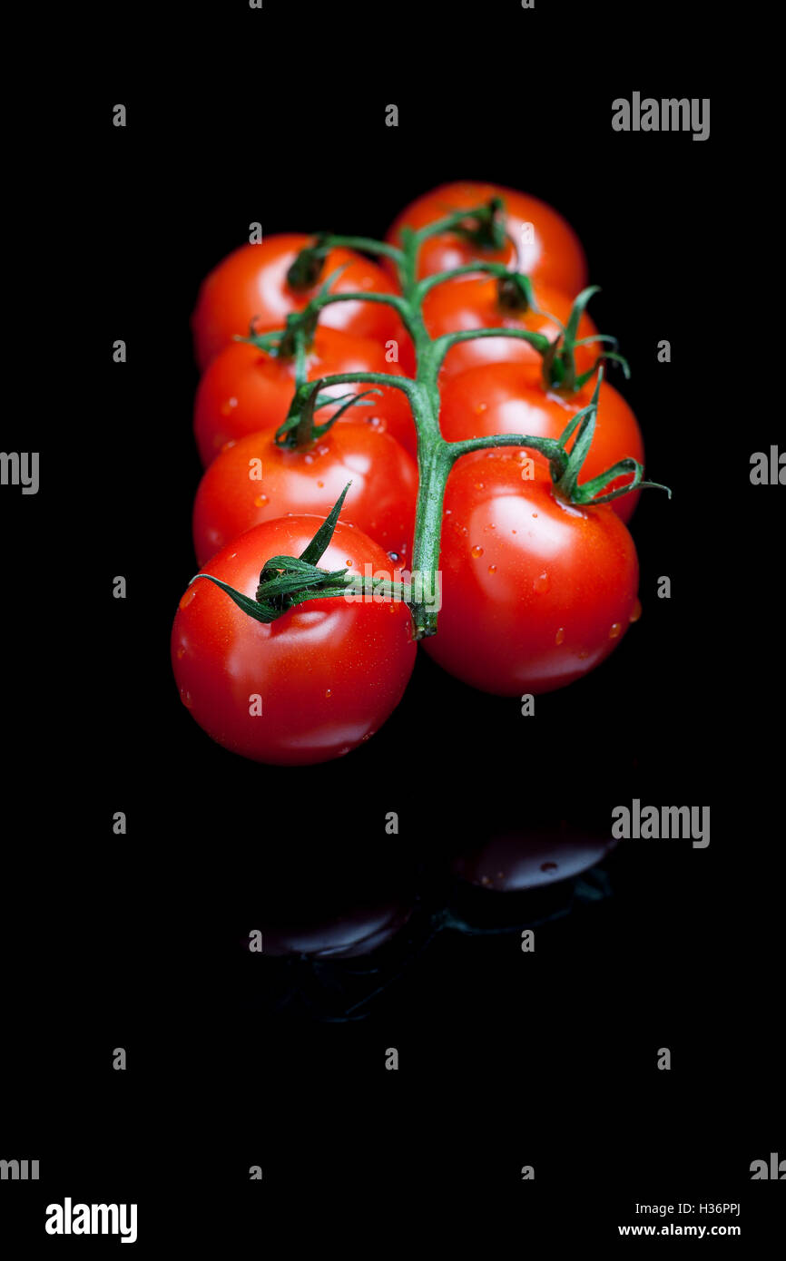 Bunch of red tomatoes on a black reflective background Stock Photo - Alamy