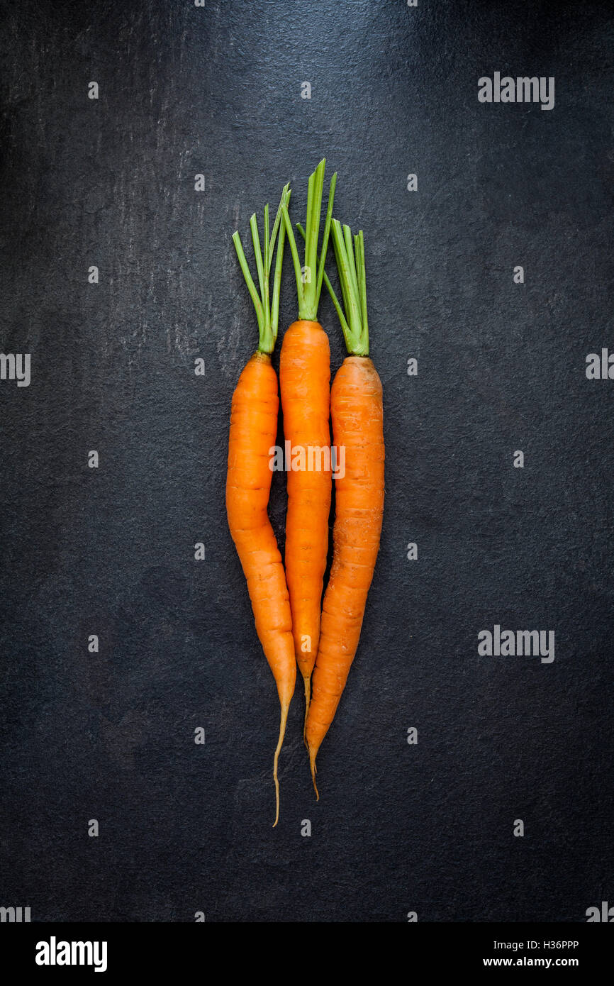 Top view of carrots on black slate background Stock Photo