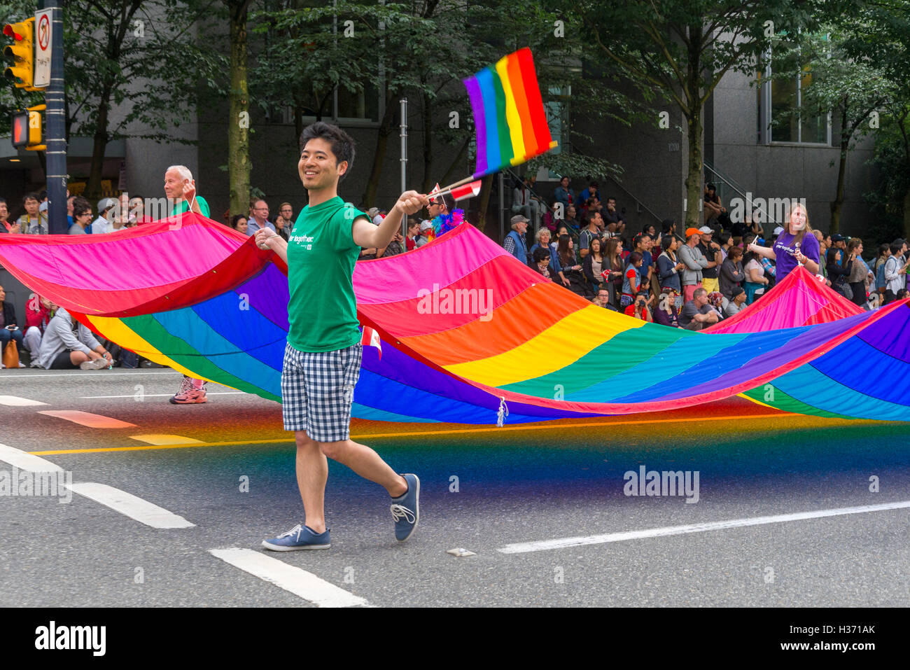 The Gay Pride Flag is carried proudly at Parade, Vancouver, British Columbia, Canada, Stock Photo