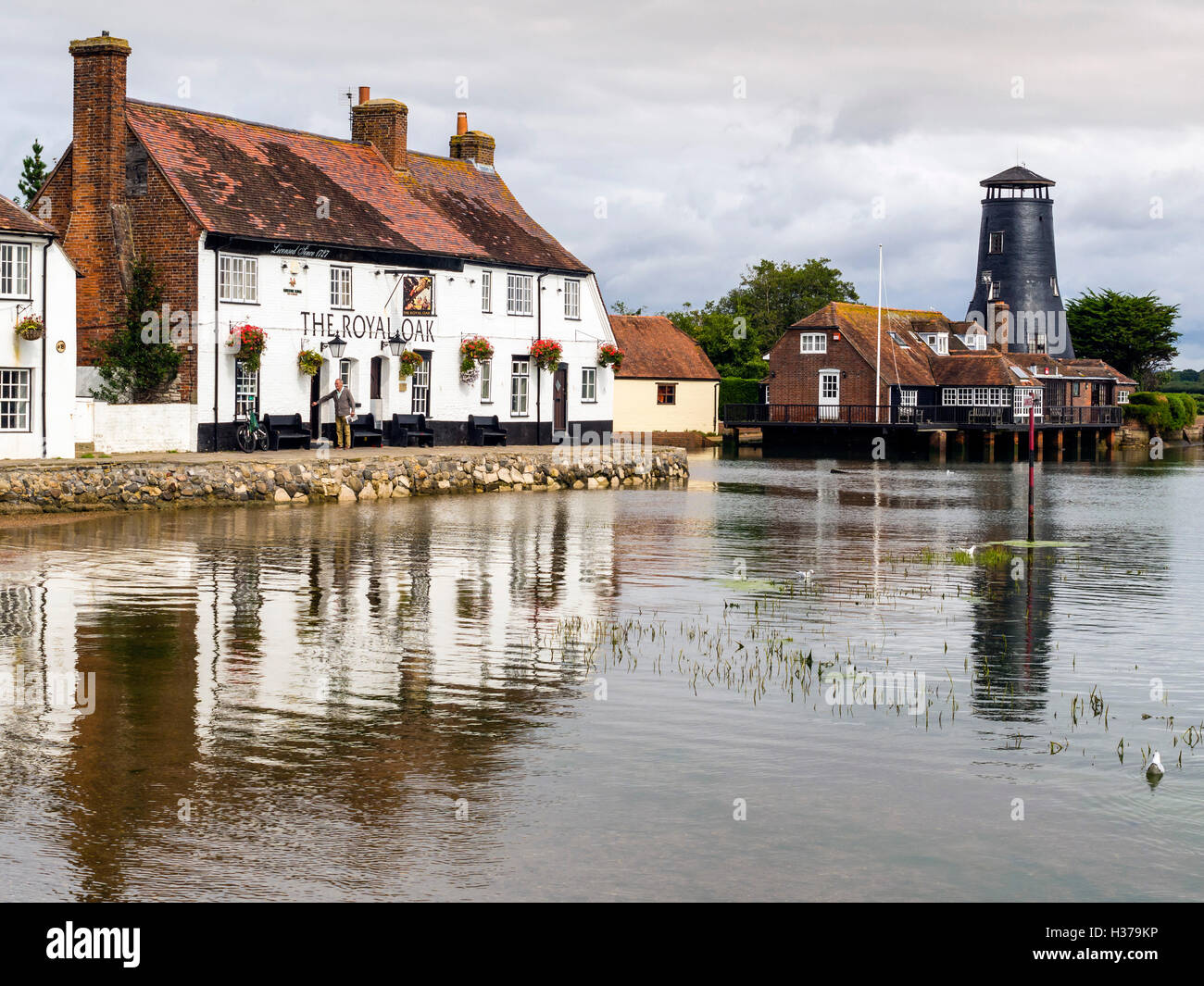 The Royal Oak public house, cottages and Windmill overlook Langstone Harbour, Havant, UK Stock Photo