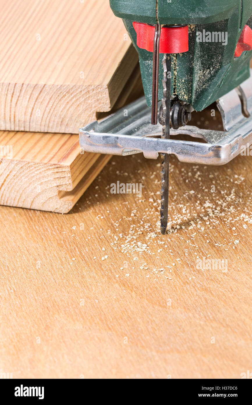 Wood planks cutting with electric fret saw tool Stock Photo