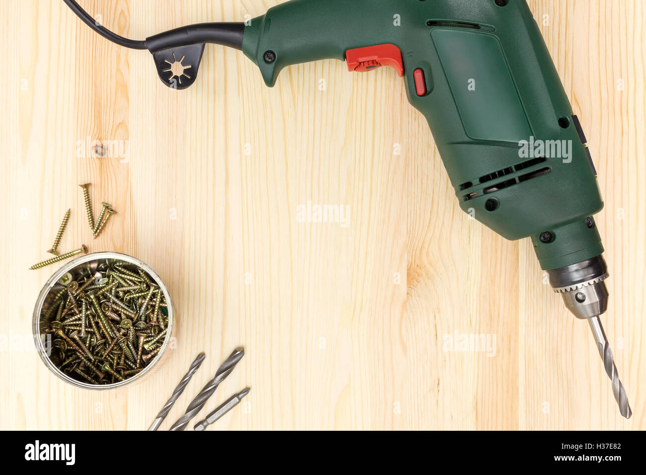 Electric drill with screws on wooden background Stock Photo Alamy