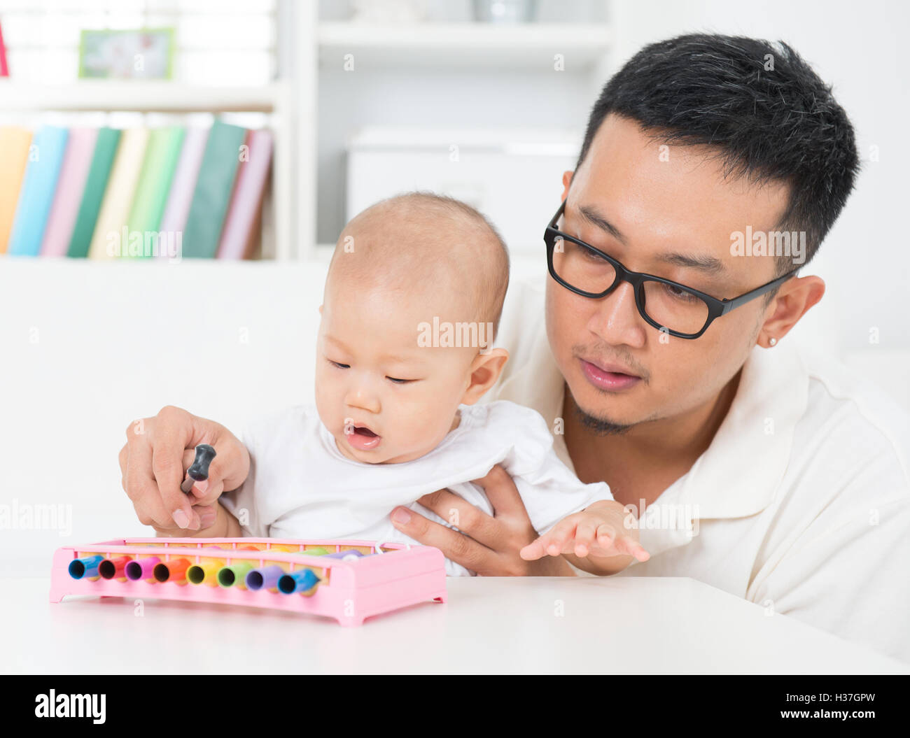 Father playing music instrument with baby. Stock Photo