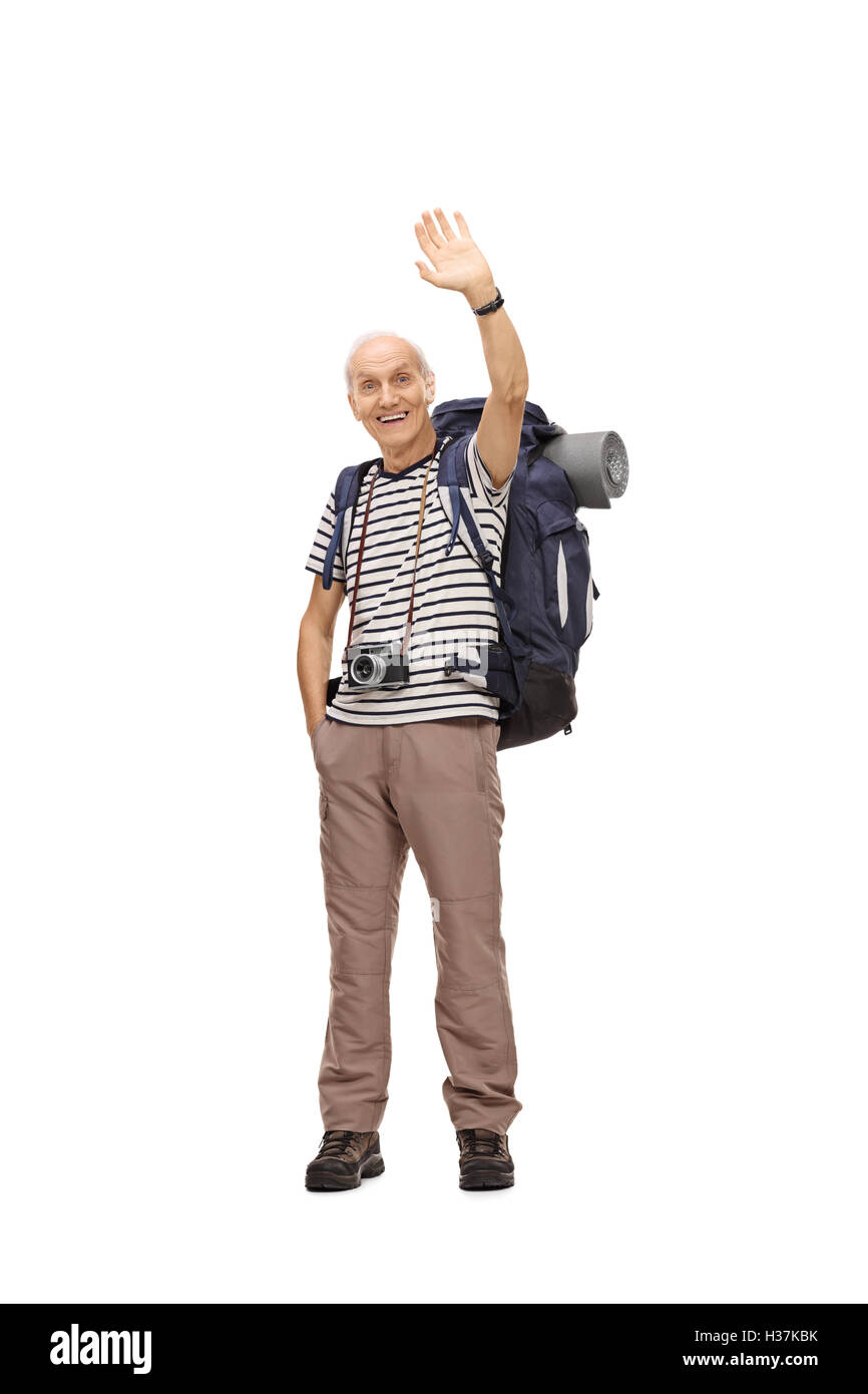 Full length portrait of a mature male hiker waving at the camera isolated on white background Stock Photo