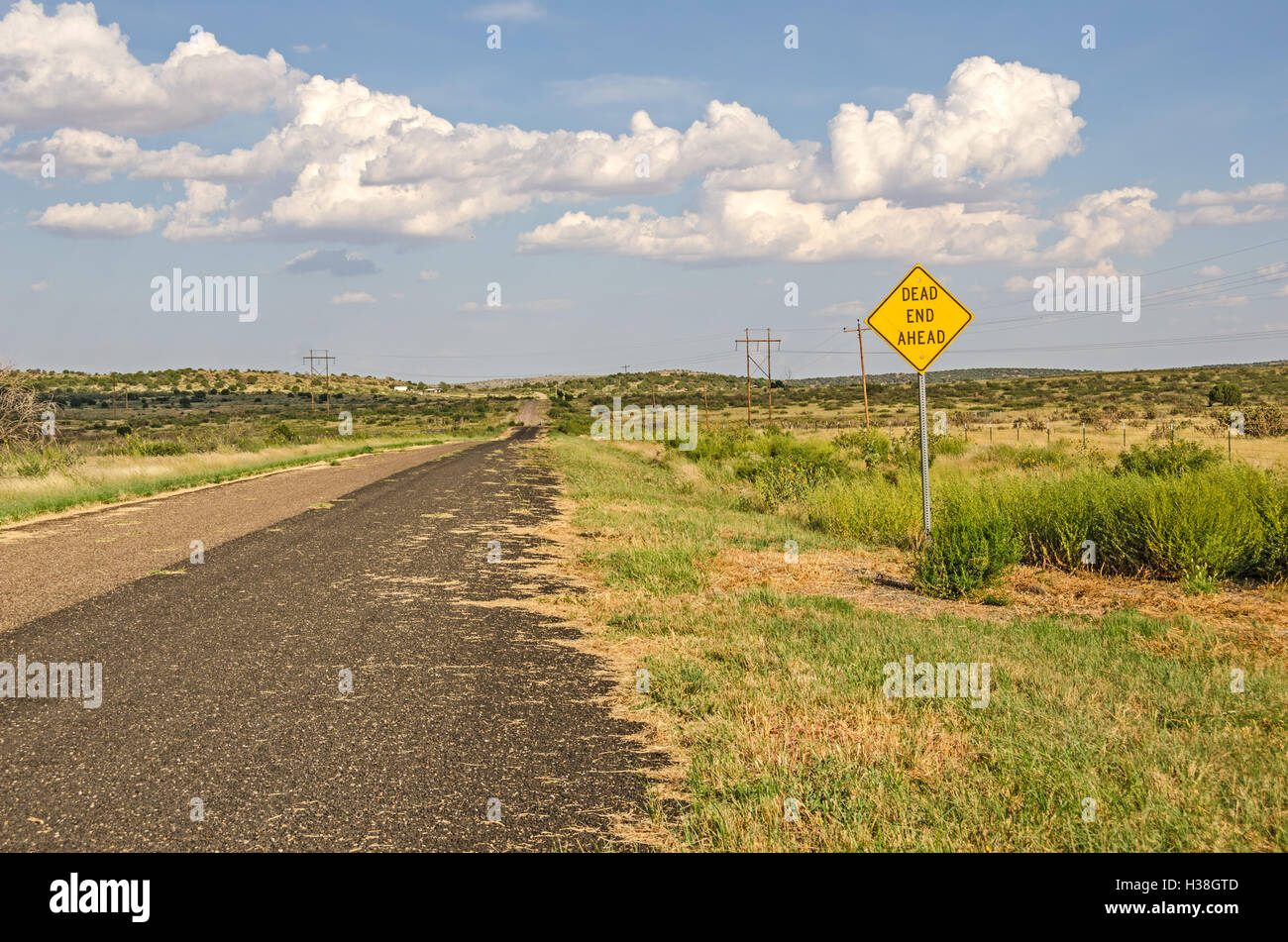 Rural area along Route 66 with a sign for a dead end ahead.  It looks like there is a gate across the road. Stock Photo