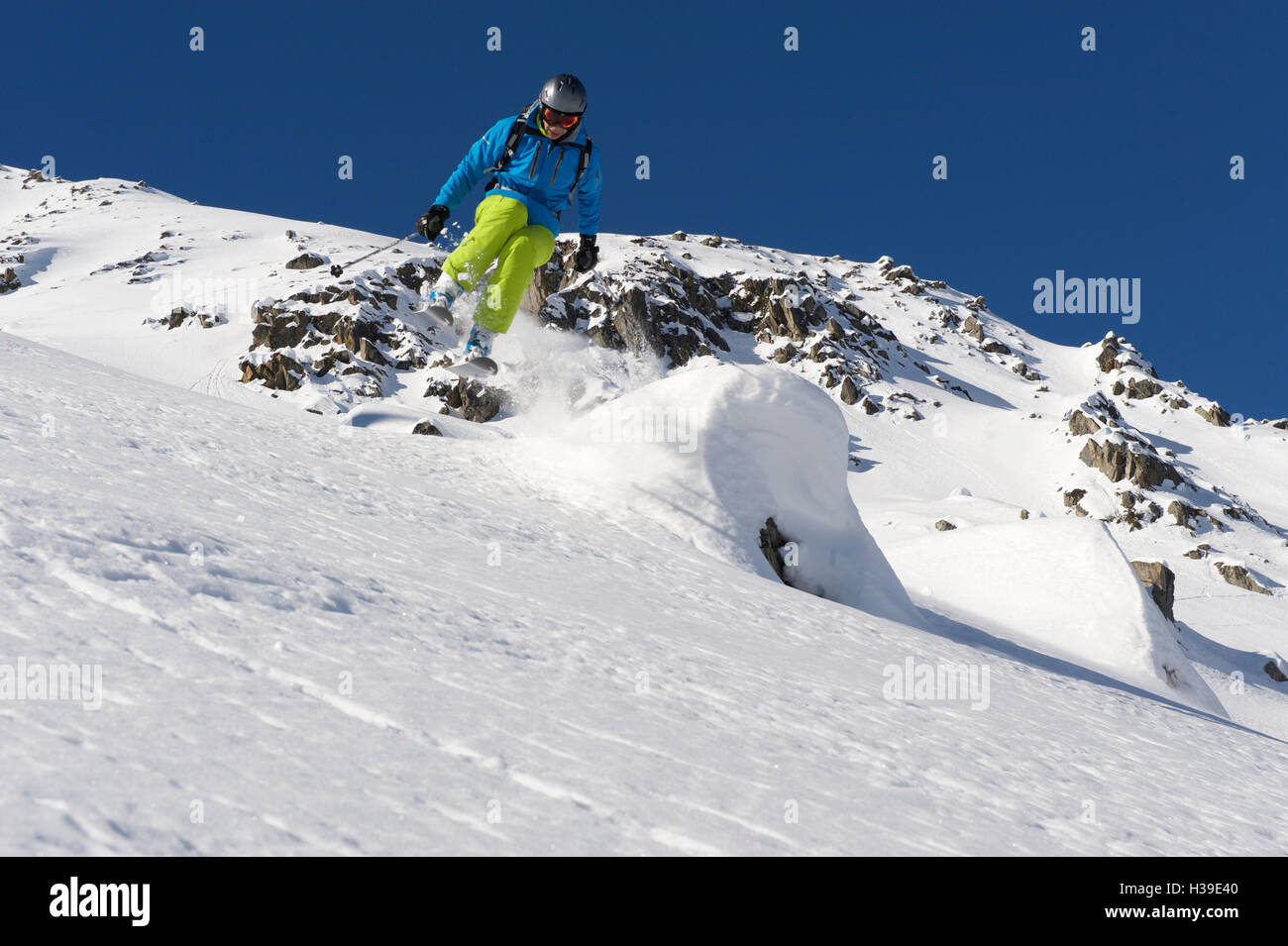 Skier jumping over a snow covered rock Stock Photo
