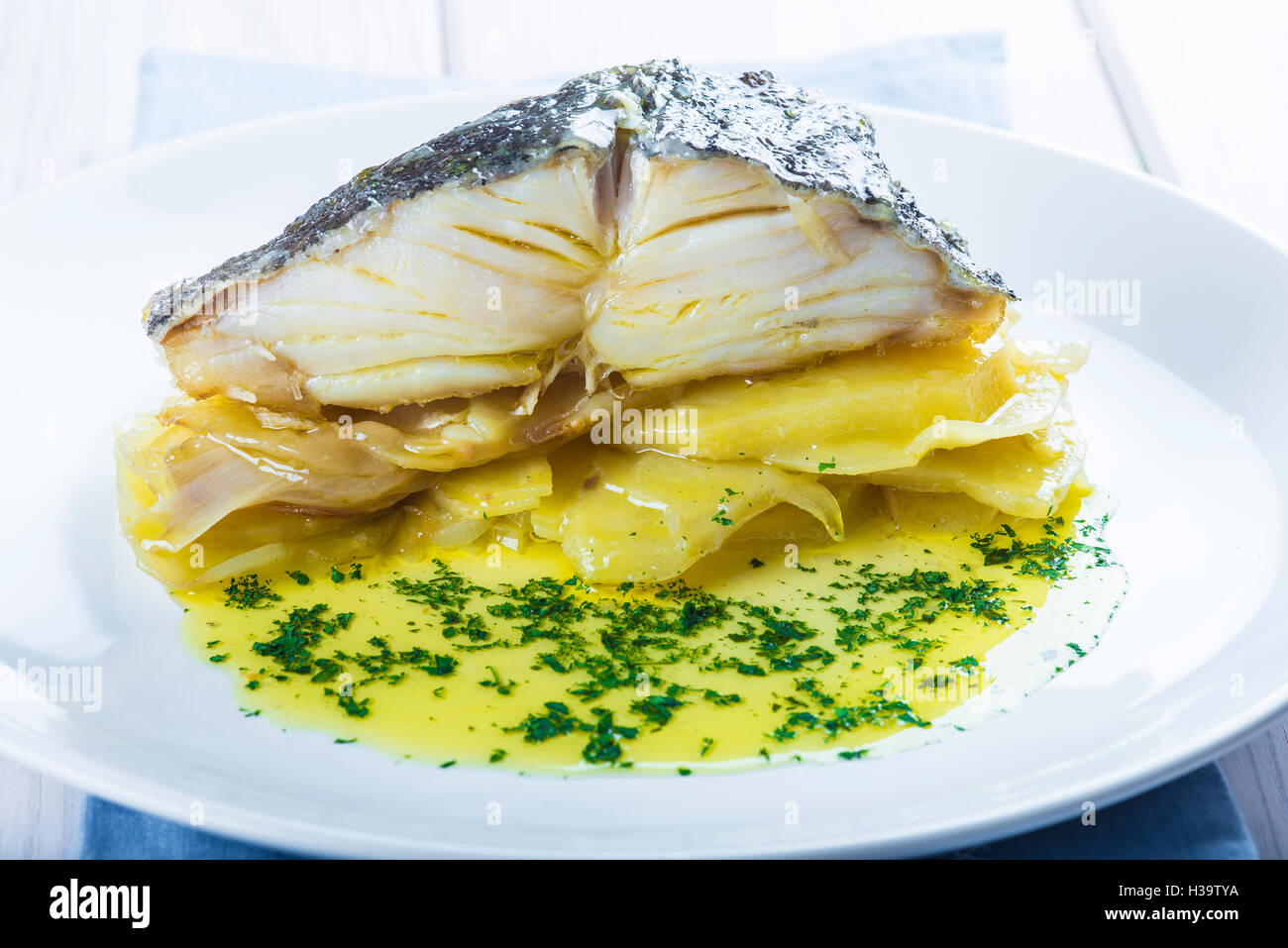 Salted cod fish oven baked with potatoes onion and olive oil Stock