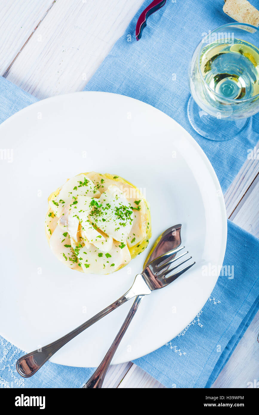 Salted cod fish oven baked with potatoes onion and olive oil Stock