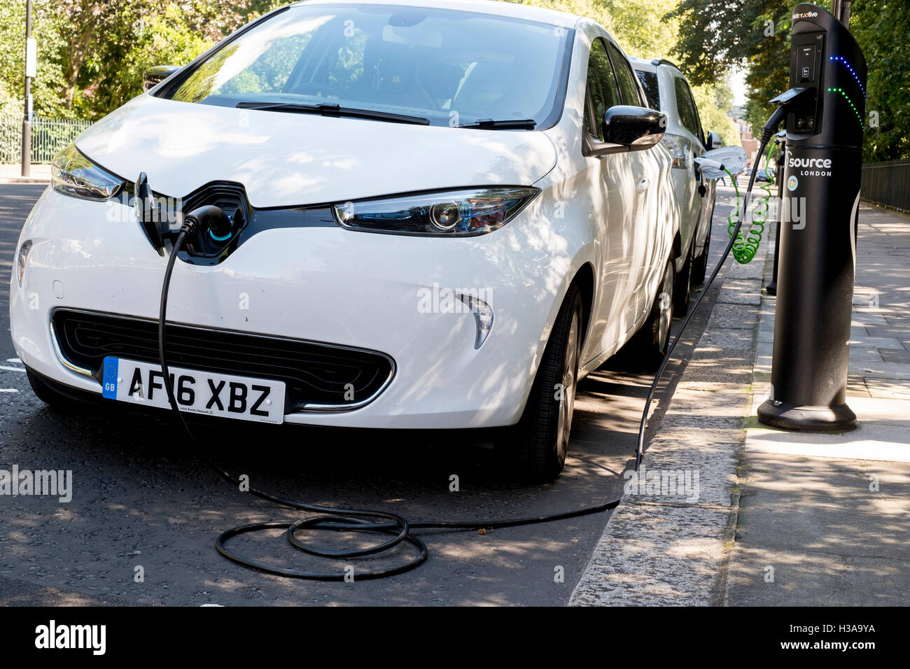 An electric car recharging via a roadside charge point in London, England, Stock Photo
