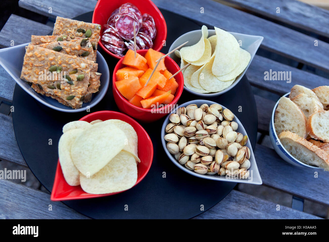 Crackers, chips, melon and sausage on a table Stock Photo