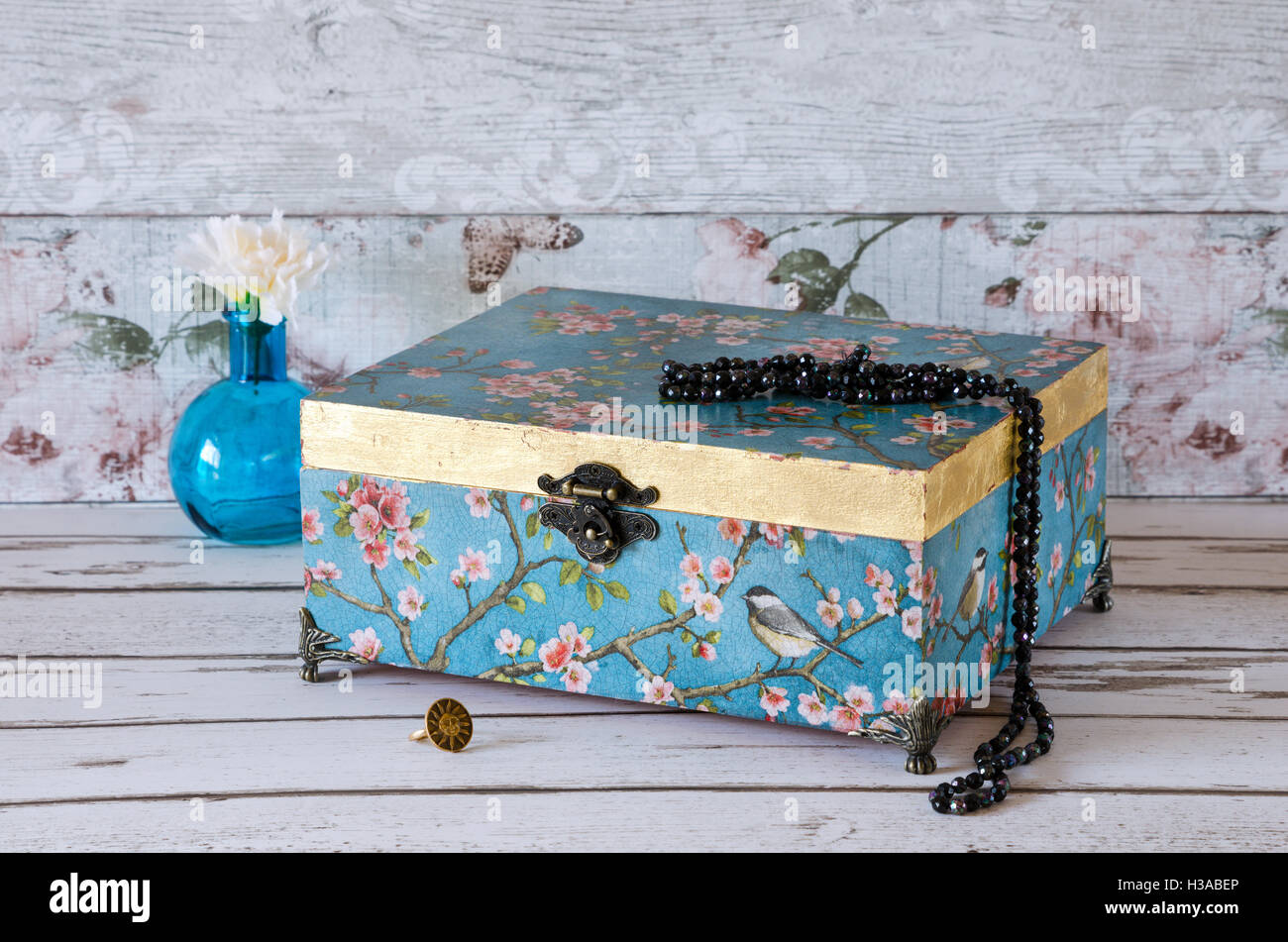 Stunning jewellery chest on a rustic background and decorated with a