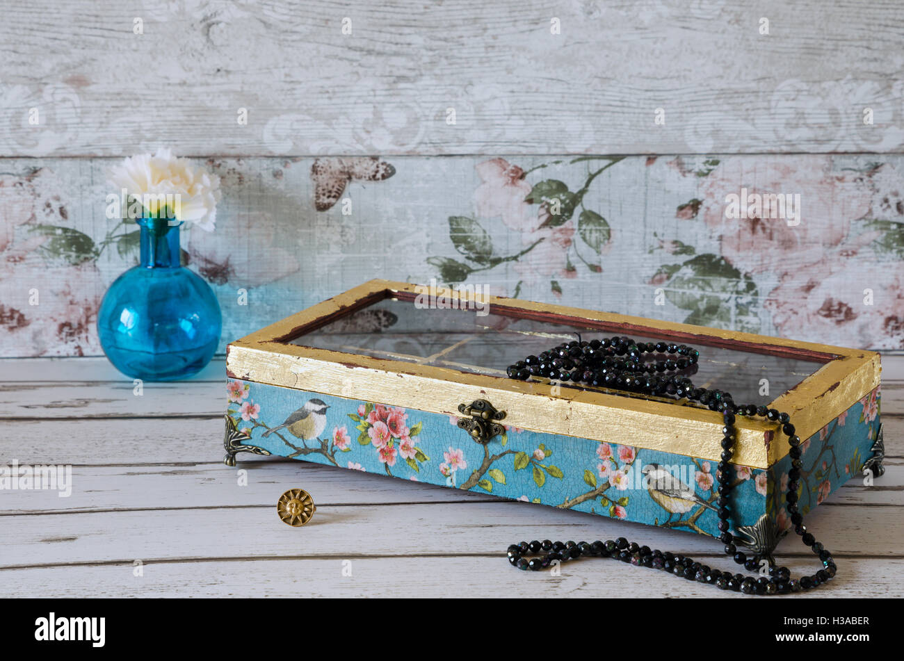 A stunning hand made jewelley box decoupaged and gilded on a rustic background Stock Photo