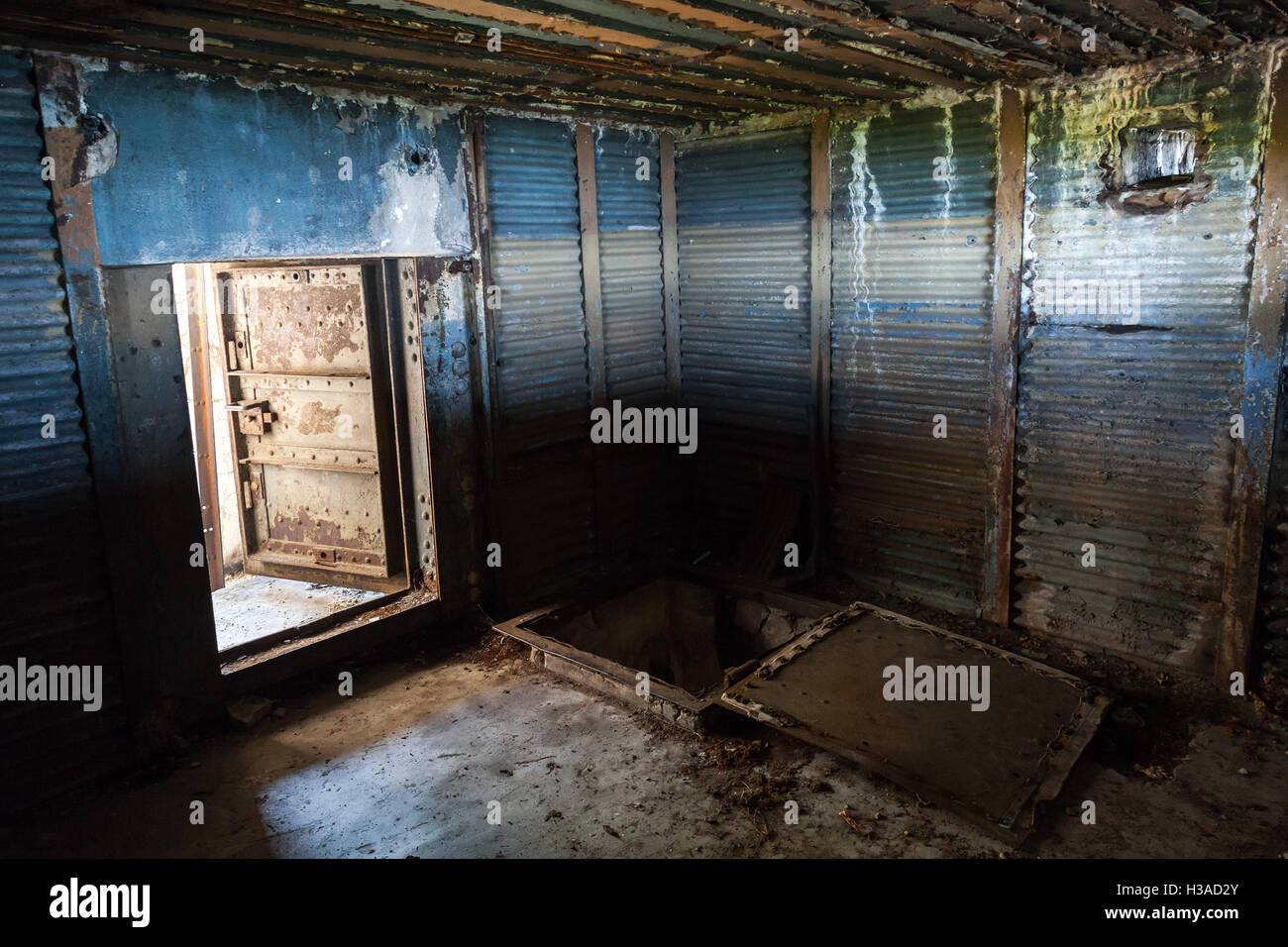 Abstract dark grungy industrial interior with blue rusted metal walls and open heavy steel door Stock Photo