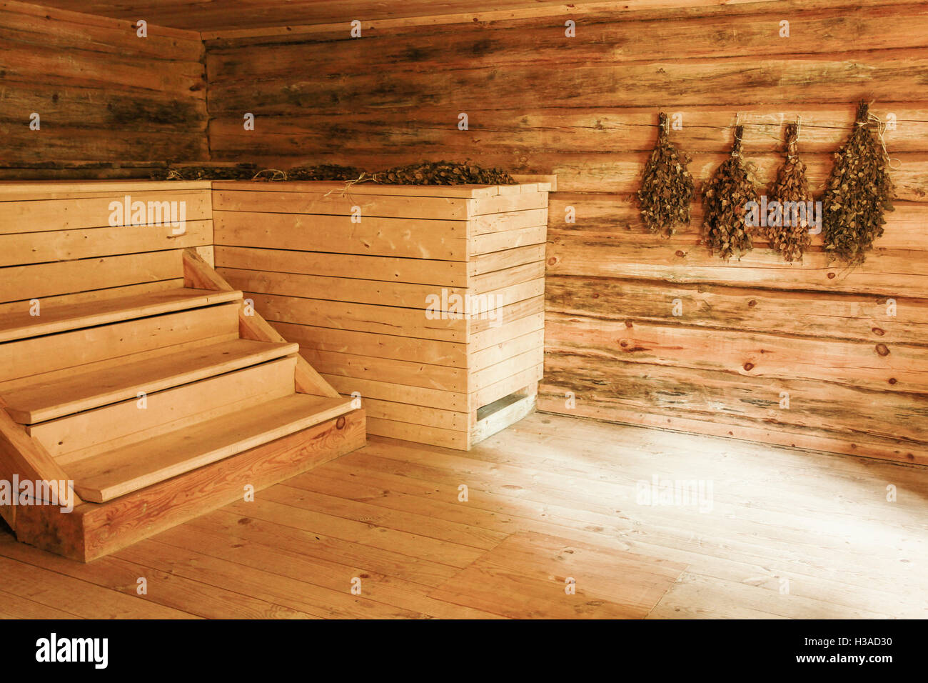 Empty wooden interior of Russian sauna with brooms on the wall Stock Photo
