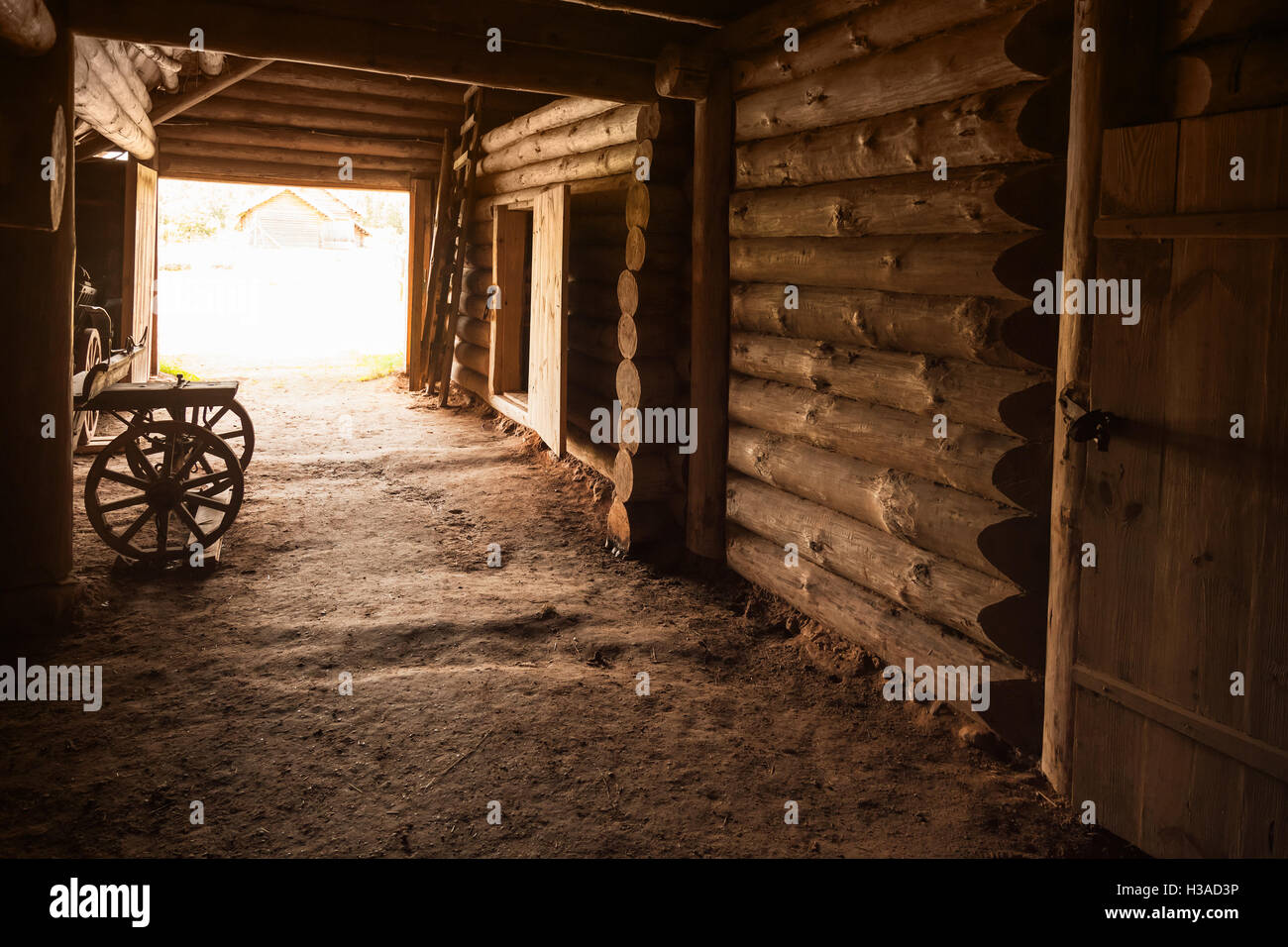 Ancient rural Russian interior. Corridor with walls made of rough logs and closed door in the end Stock Photo