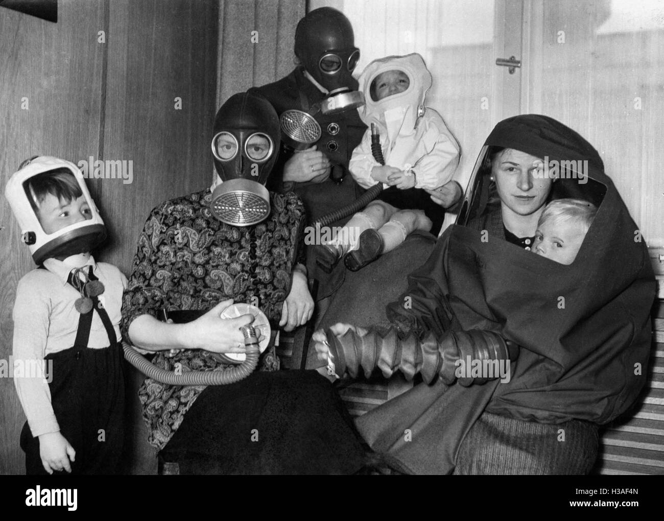Family in air-raid protection gear, undated Stock Photo