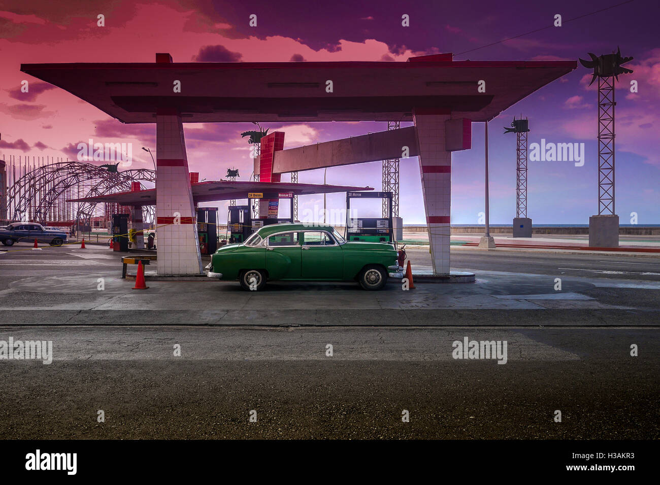 Old American car that is left in Gas station, during a beautiful red sunset above Havana In Cuba Stock Photo