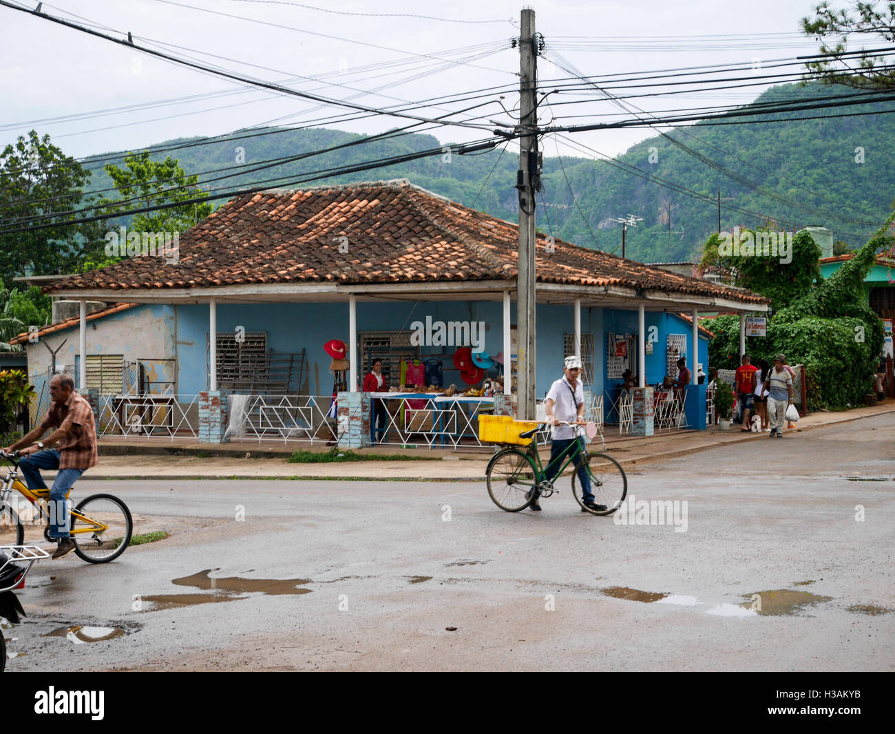 Cuban scenery, people are living their life on the streets, with a mountains in a background. Stock Photo