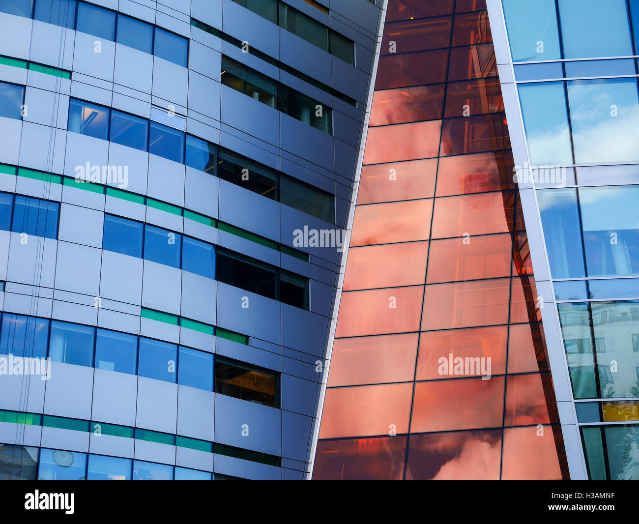 Modern office building in the heart of Oslo Norway, shiny glass of blue orange and green colours in shapes, reflective surfaces Stock Photo