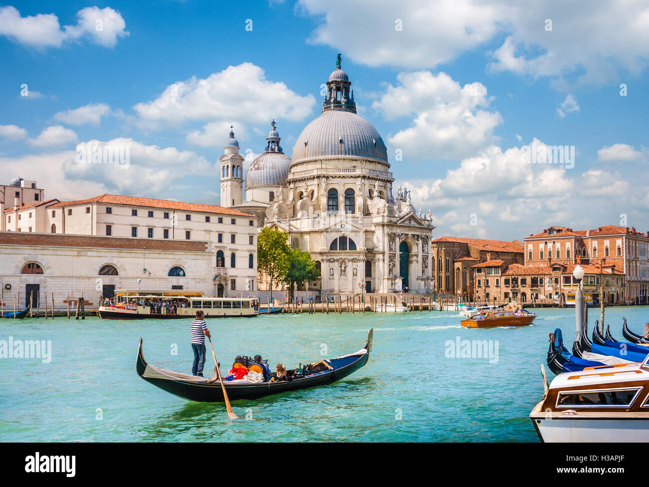 Traditional Gondola on Canal Grande with historic Basilica di Santa Maria della Salute in the background, Venice, Italy Stock Photo