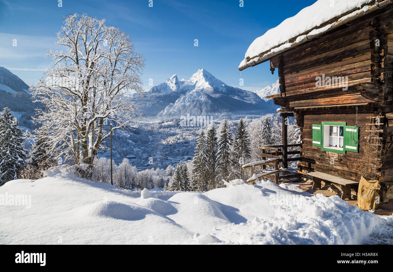 Winter wonderland mountain scenery in the Alps with traditional mountain chalet on a cold sunny day Stock Photo