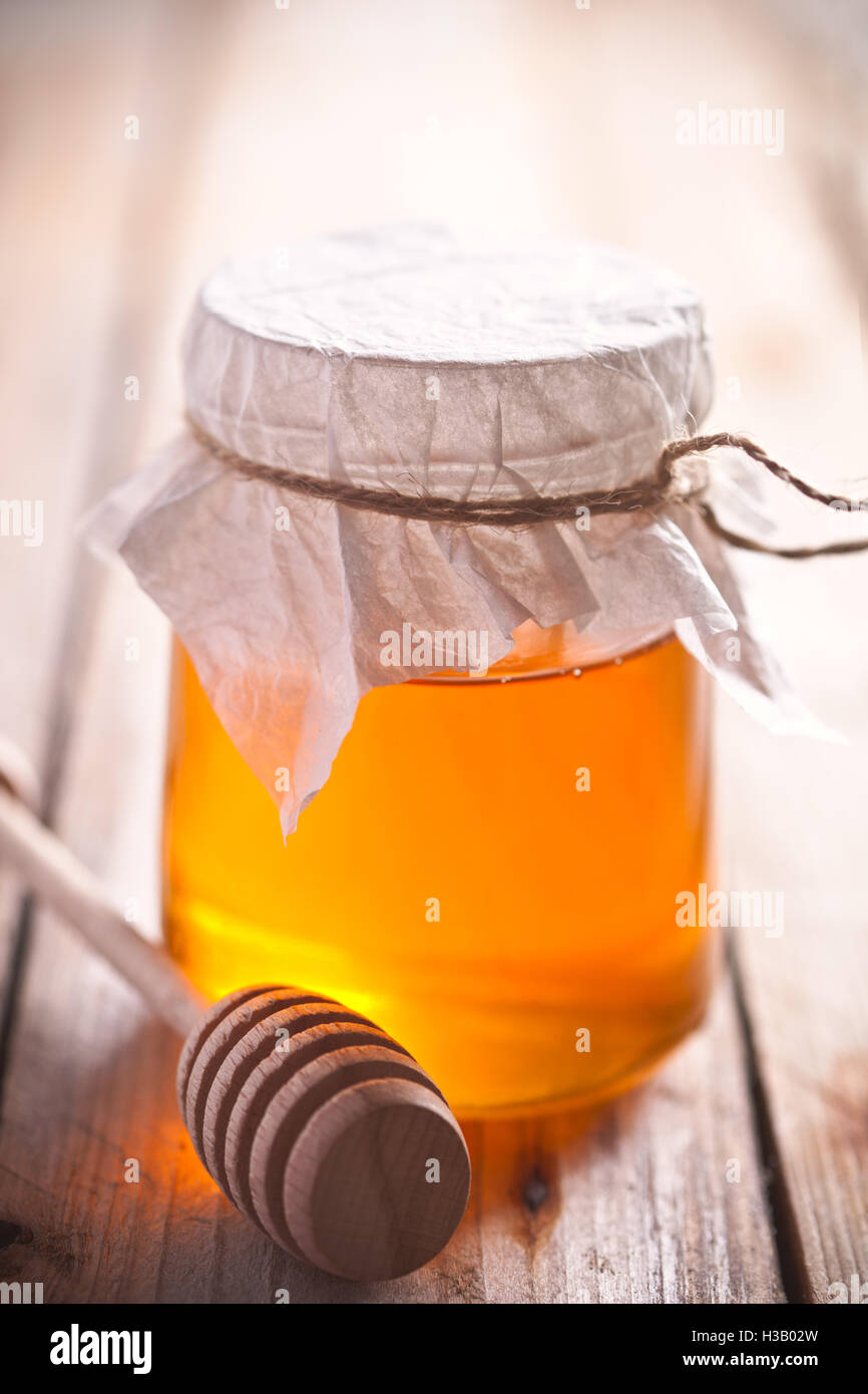 full honey pot and honey stick Stock Photo Alamy