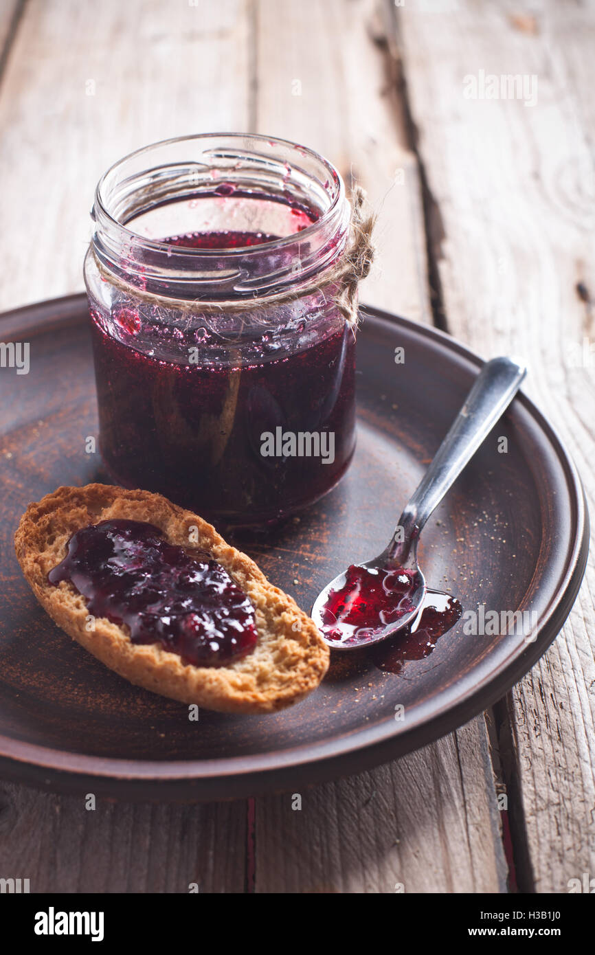 black currant jam in glass jar and crackers Stock Photo