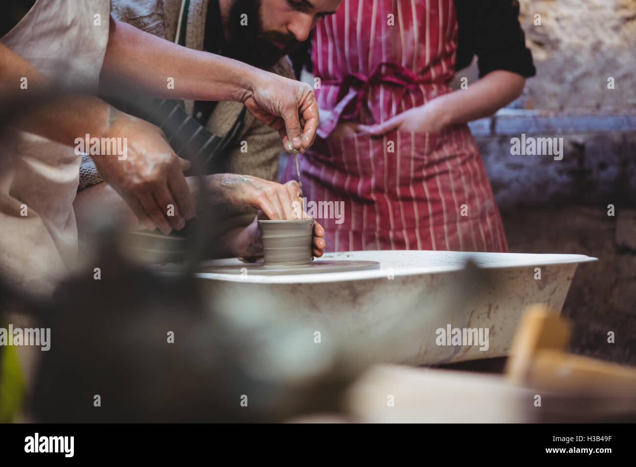 Cropped image of potters working Stock Photo - Alamy
